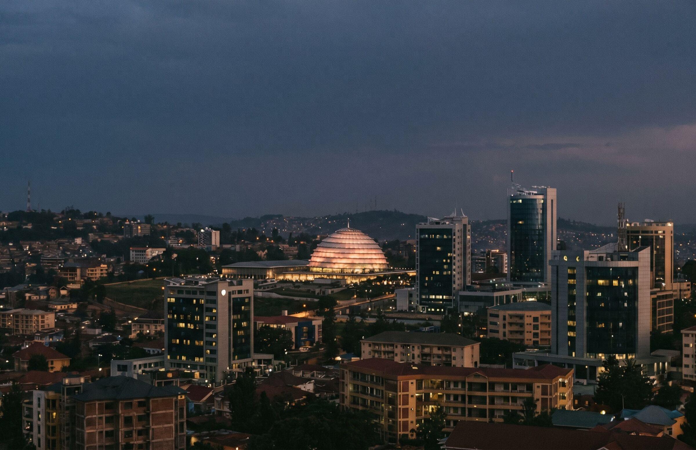 Kigali skyline at blue hour — the Kigali Convention Centre dome lit from inside.
